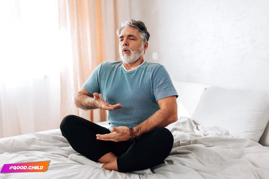 Watch as this man demonstrates his peaceful morning routine, practicing yoga in bed. He moves his body with ease and grace, promoting relaxation and calmness